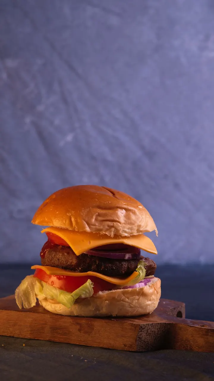 Cheeseburger sobre tabla de madera, Brasa & Humo, San José