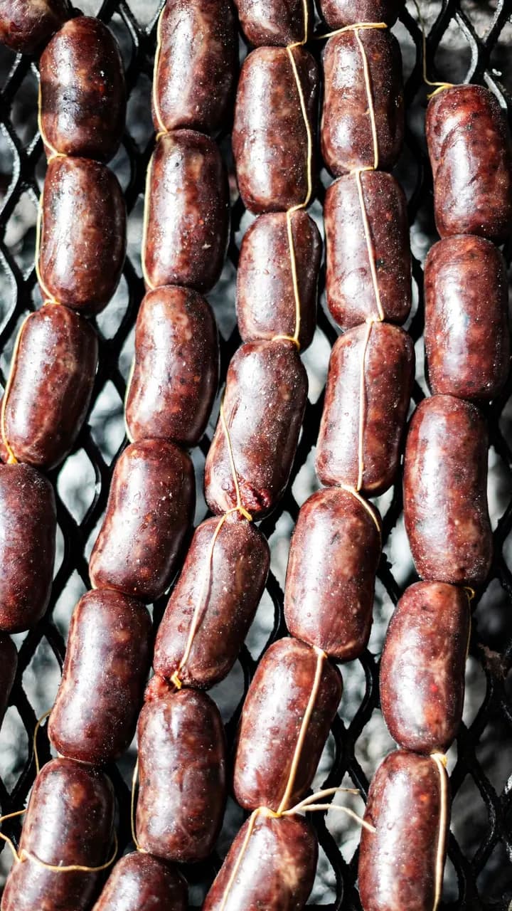 Chorizos asándose en la parrilla, Brasa & Humo, San José