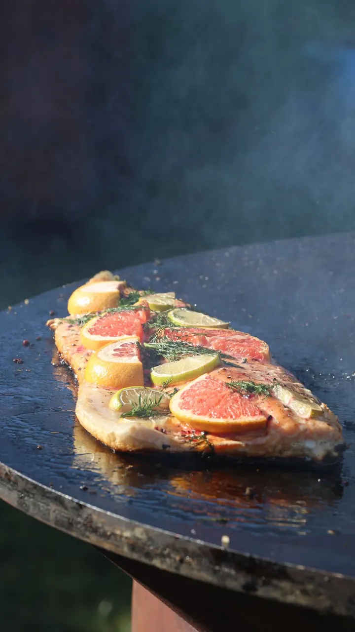 Salmón asándose sobre la parrilla con cítricos, Brasa & Humo, San José